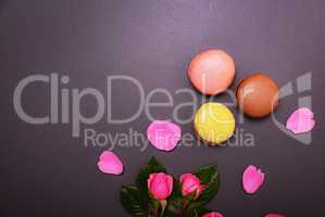 pink roses and three multicolored macaroons