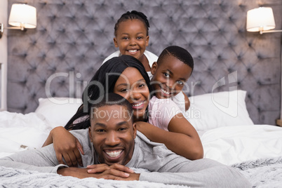 Portrait of smiling family lying on bed