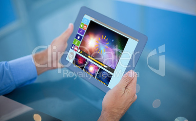 Composite image of businessman using his tablet