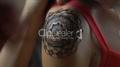 Woman gets henna tattoo on her shoulder