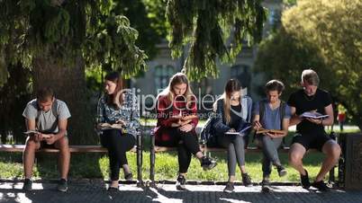 Concentrated classmates learning together outdoors