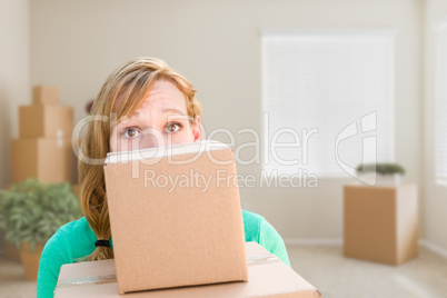 Happy Young Adult Woman Holding Moving Boxes In Empty Room In A