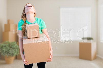 Tired Young Adult Woman Holding Moving Boxes In Empty Room In A