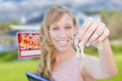 Excited Woman Holding House Keys and Sold Real Estate Sign in Fr