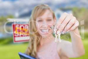 Excited Woman Holding House Keys and Sold Real Estate Sign in Fr