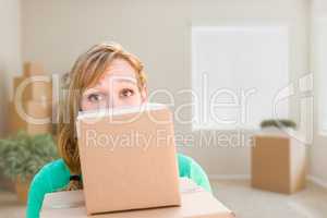 Happy Young Adult Woman Holding Moving Boxes In Empty Room In A
