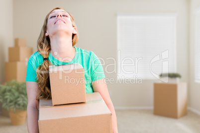 Tired Young Adult Woman Holding Moving Boxes In Empty Room In A