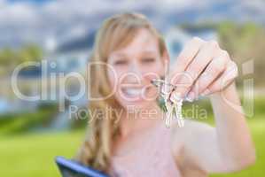 Excited Woman Holding House Keys in Front of Nice New Home.