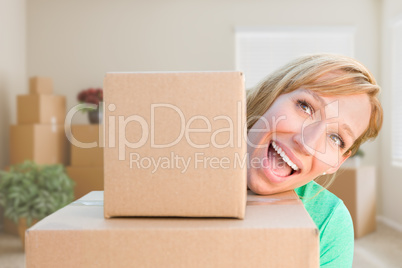 Happy Young Adult Woman Holding Moving Boxes In Empty Room In A