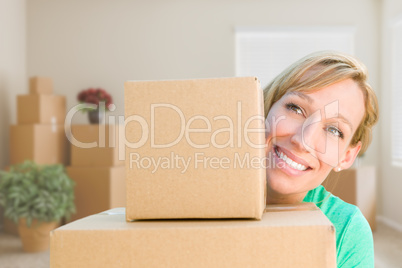 Happy Young Adult Woman Holding Moving Boxes In Empty Room In A