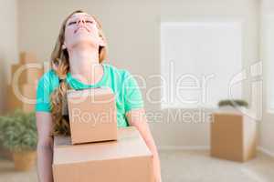 Tired Young Adult Woman Holding Moving Boxes In Empty Room In A