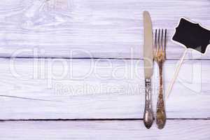 Iron fork and knife on a white wooden surface