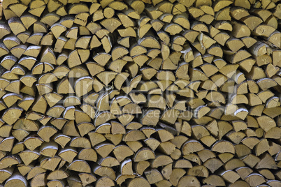 The firewood is stacked in a woodpile. Decorative wall of firewo