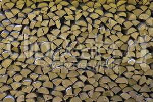 The firewood is stacked in a woodpile. Decorative wall of firewo