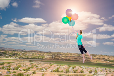 Young Girl Being Carried Up and Away By Balloons That She Is Hol