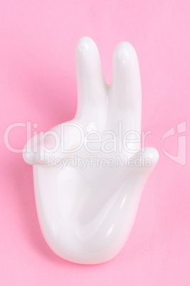 Ceramic stand with hand shape on pink background