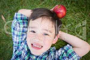 Mixed Race Chinese and Caucasian Young Boy With Apple Relaxing O