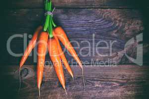 Bunched fresh carrots on a wooden table