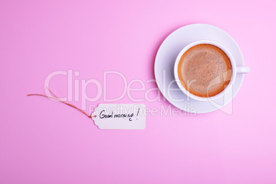 cup of coffee and a saucer and a paper tag