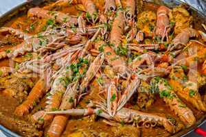 Paella with seafood and vegetables in a pan