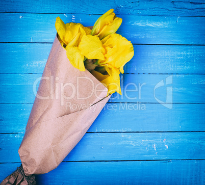 yellow irises wrapped in brown kraft paper