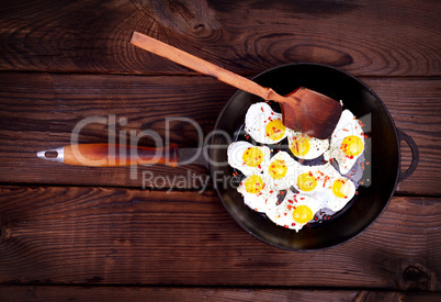 Fried quail eggs in a black frying pan
