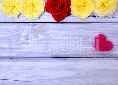 Red knitted heart on a white wooden background