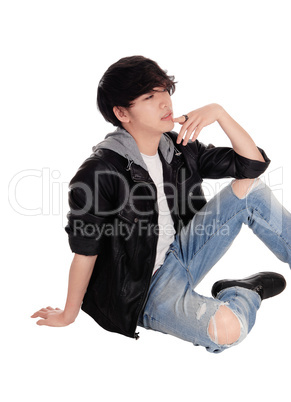 Young Asian man sitting on floor.