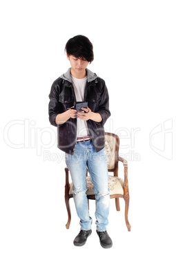 Asian teenager looking at his cellphone.