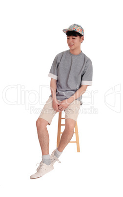 Asian man sitting and smiling.