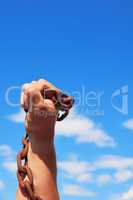 male hand holds a rusty metal chain