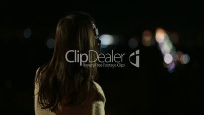 Woman in headphones listening to music at night