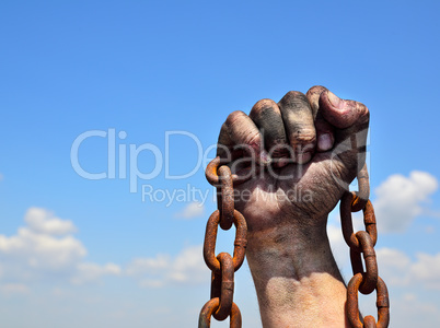Rusty iron chain in human male right hand