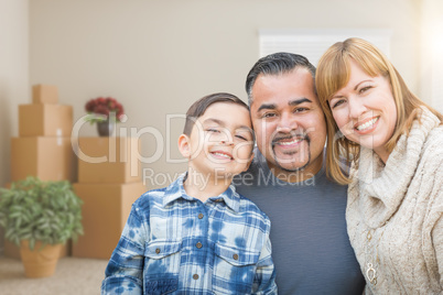 Mixed Race Family In Empty Room With Moving Boxes and Plants.