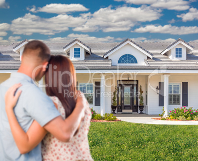 Young Military Couple Facing Beautiful New House.