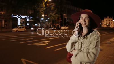 Happy girl talking on mobile phone in night city