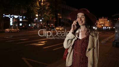 Beautiful girl using smortphone on street at night