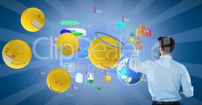 Businessman analyzing graphs on blue background by 3d various emojis