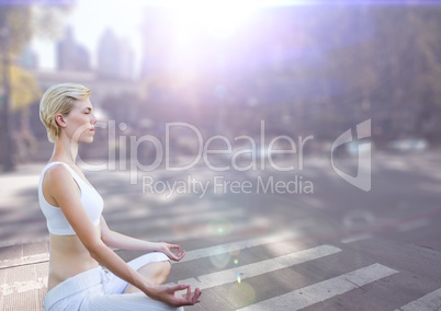 Woman meditating against street with flares