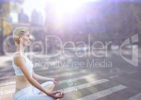 Woman meditating against street with flares