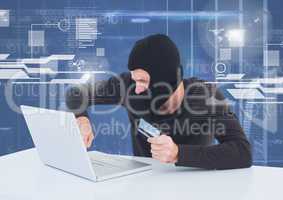 Hacker using a laptop and holding a credit card in front of 3D digital background