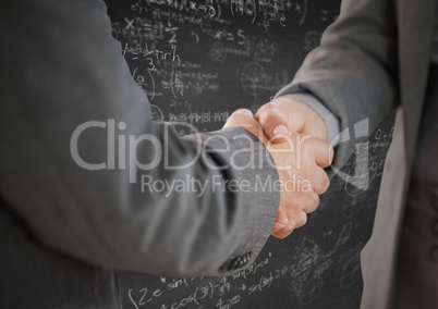 Handshake against grey wall with math doodles