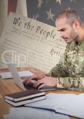 Proud soldier using a laptop with american flag background