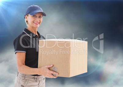 Middle aged delivery woman with box against clouds and flares