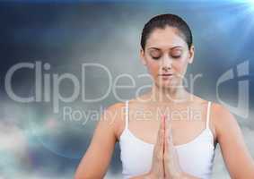 Woman meditating against cloud and flares