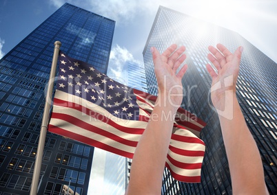 Arm raised against american flag and scyscrapers