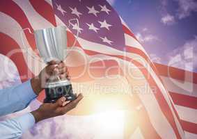 Part of a man holding a cup against fluttering american flag