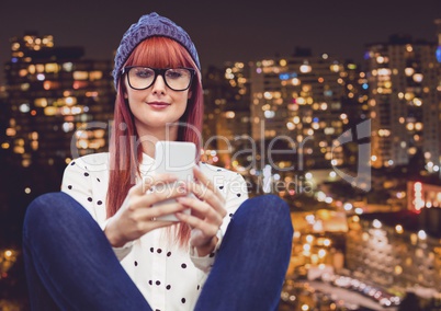 Smiling woman texting with a city in background