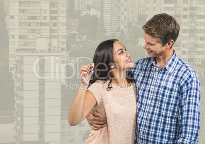 Couple Holding Keys with city high rises