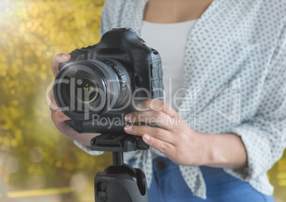 photographer hands with reflex (foregrund) in the park. Flares and lights